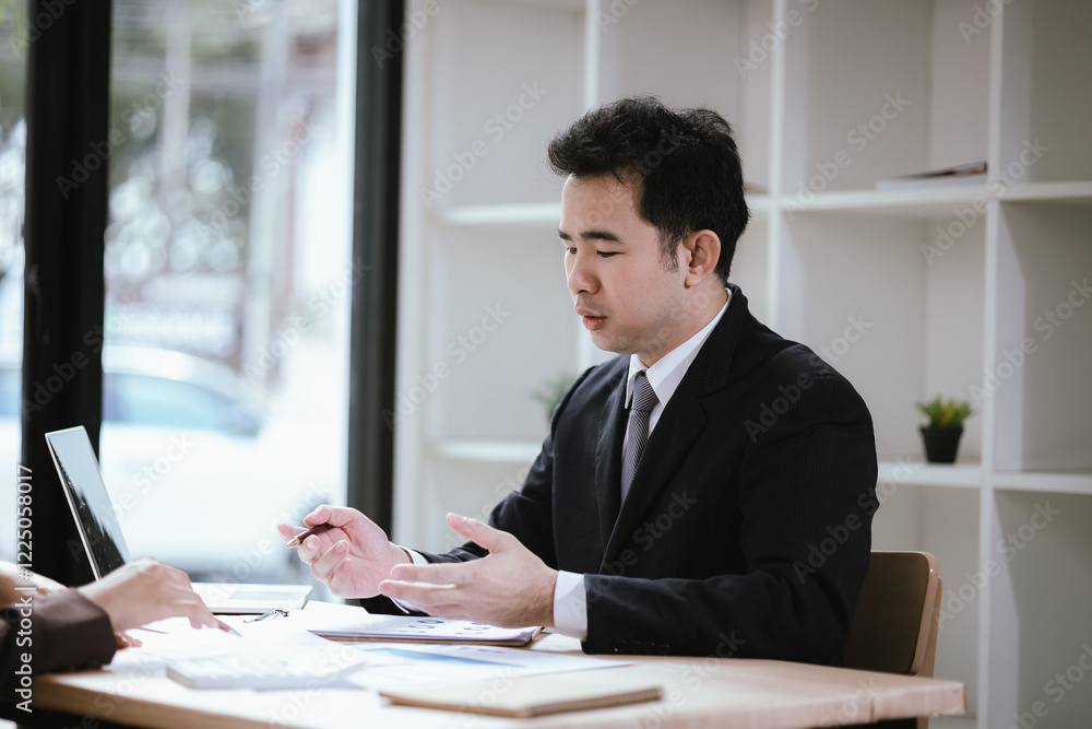 A team of business professionals work together in an office to analyze financial reports, sales strategies, and market statistics using laptops, documents, and graphs. A team of business professionals work together in an office to analyze financial reports, sales strategies, and market statistics using laptops, documents, and graphs.