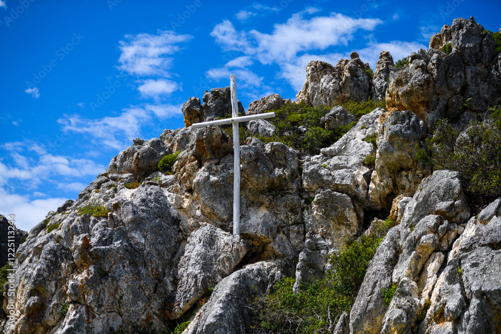 Fototapeta premium Christian cross on the hill side with clouds in the background