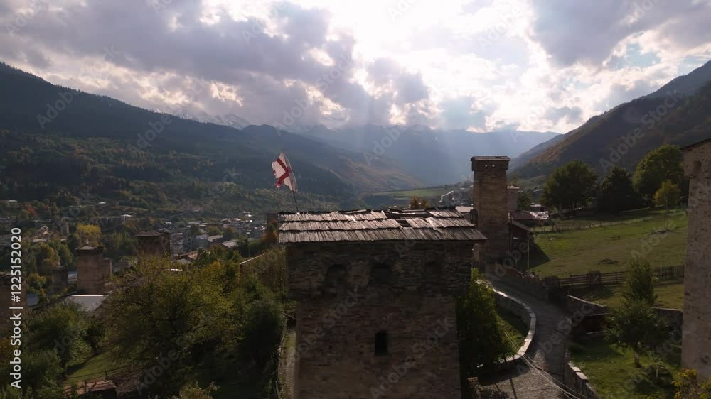 Georgian flag on an ancient tower in the mountains Georgian flag on an ancient tower in the mountains