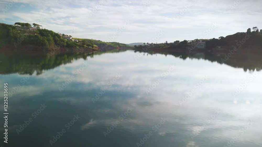 aerial view of a lake in Igarata, countryside of Sao Paulo state in Brazil. In the middle of the Atlantic forest with green forest and blue sky during during sunrise aerial view of a lake in Igarata, countryside of Sao Paulo state in Brazil. In the middle of the Atlantic forest with green forest and blue sky during during sunrise