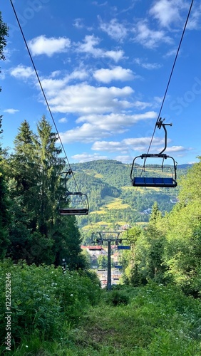 Vertical photo of a funicular going up the mountain among trees in summer, in Szczawnica, Pieniny National Park, Poland. Perfect for active lifestyle, hiking, traveling, and outdoor adventure themes
