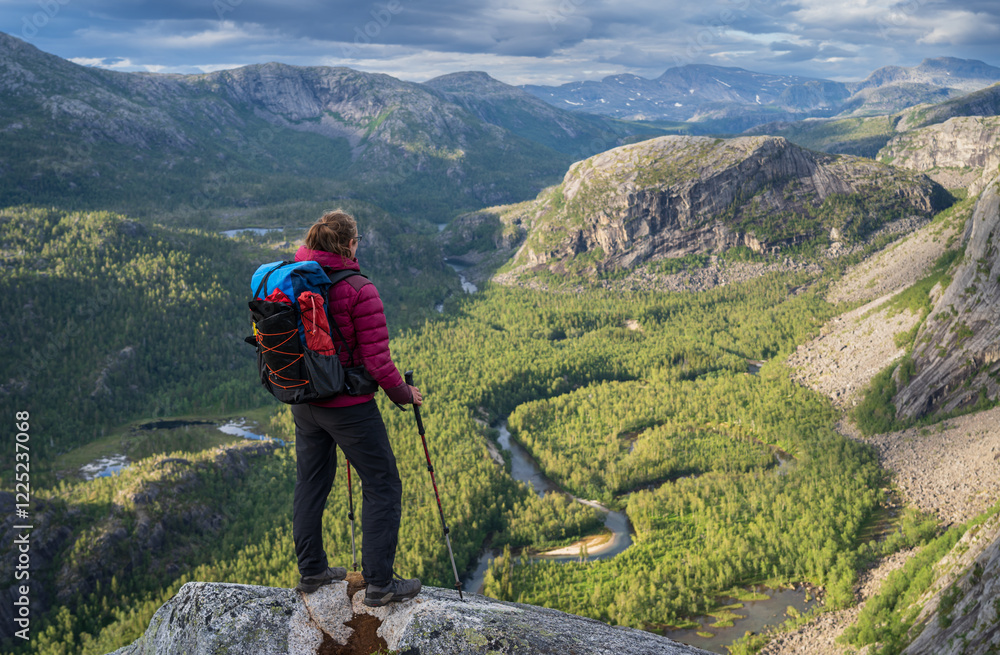Hiker looking over the valley in National Park Rago, Norway.
