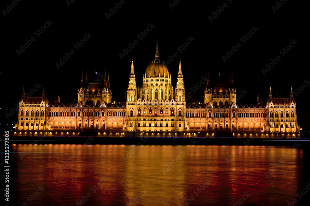 Fototapeta premium Danube side elevation of the Parliament building Budapest, Hungary. night photo. brightly lit stone facade. neo-gothic style architecture. famous landmark. popular tourist attraction. travel, tourism