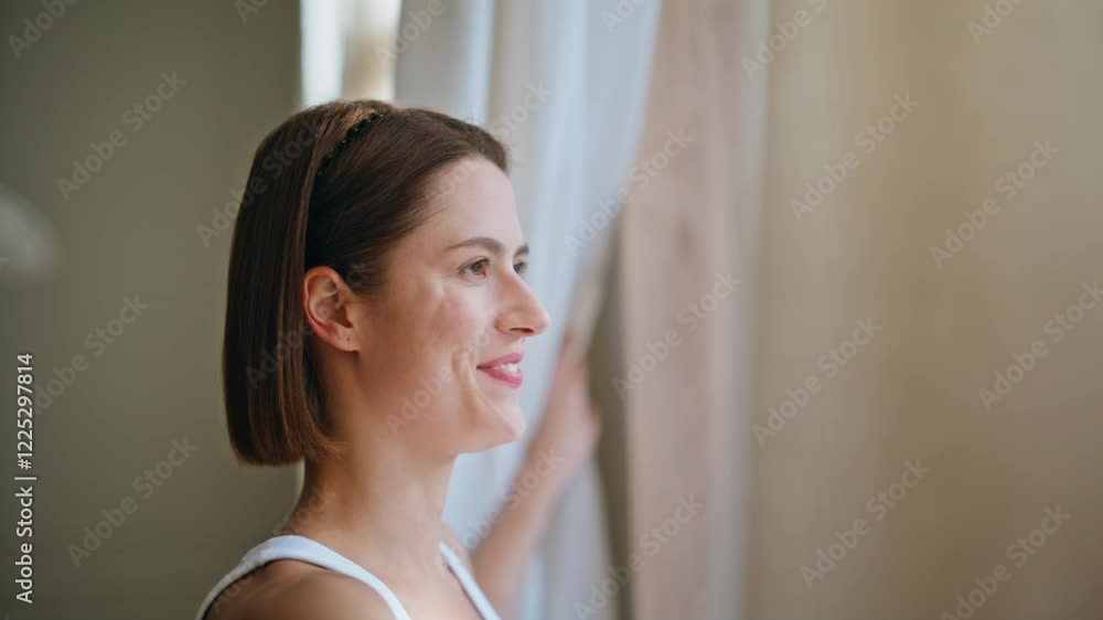Happy woman opening curtains letting soft natural light into living room closeup Happy woman opening curtains letting soft natural light into living room closeup