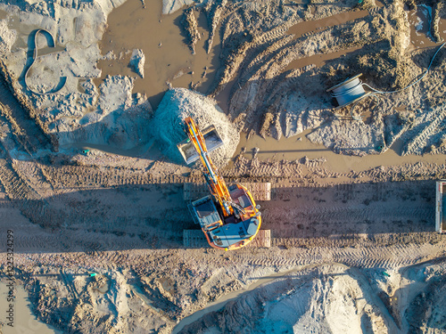 Topdown aerial of heavy machinery doing earth excavation groundworks photo