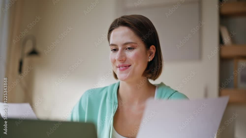 Successful woman studying documents looking laptop screen at home closeup. Successful woman studying documents looking laptop screen at home closeup.