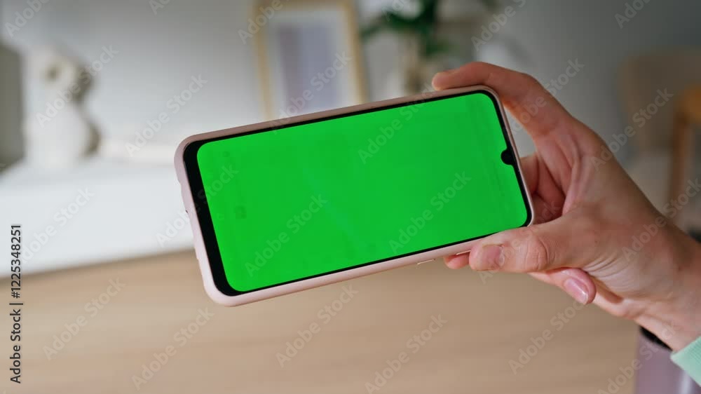 Hand holding horizontal mockup mobile phone in modern apartment closeup. Hand holding horizontal mockup mobile phone in modern apartment closeup.