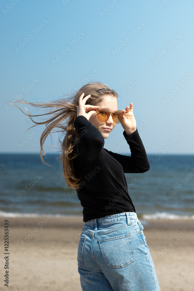 Playful teenage girl in sunglasses having fun on the beach. Playful teenage girl in sunglasses having fun on the beach.