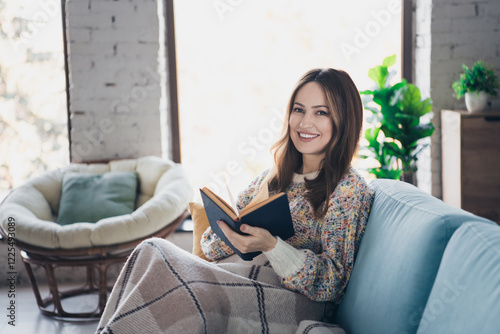 Young woman reading book at home cozy interior during a relaxing day
