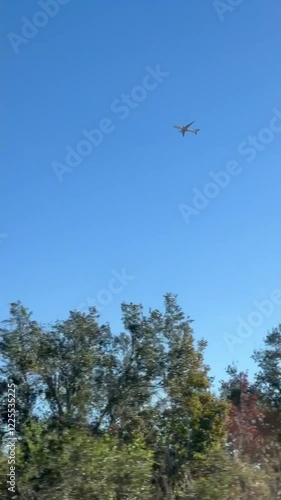 Airplane flying over the sky seen from a car window