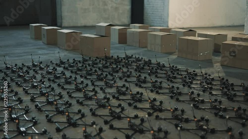 Young people lay out fpv drones and quadcopters on the floor.