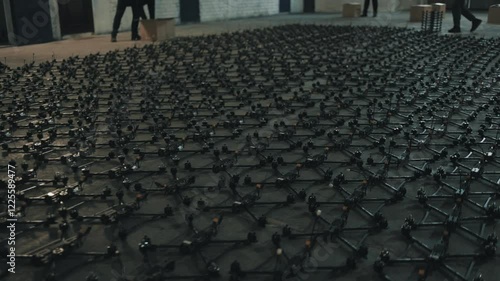 Young people lay out fpv drones and quadcopters on the floor.