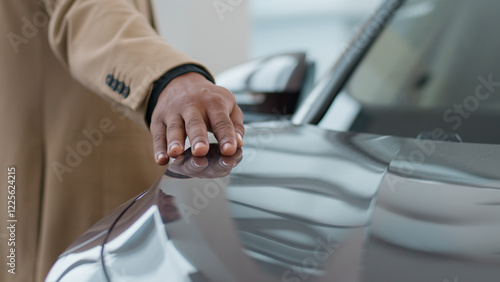 Fotografie Male hand on new electric lead car headlight future of auto industry eco modern crossover automobile sale at dealership showroom