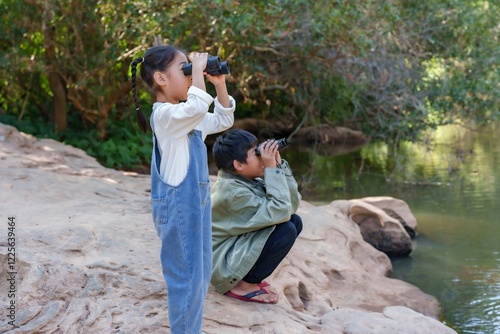Fototapet Two cute Asian brothers and sisters use telescope watch birds