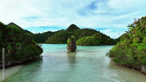 Aerial view of beautiful tropical islands with pristine beaches and clear blue lagoons, Raja Ampat Regency, Indonesia.