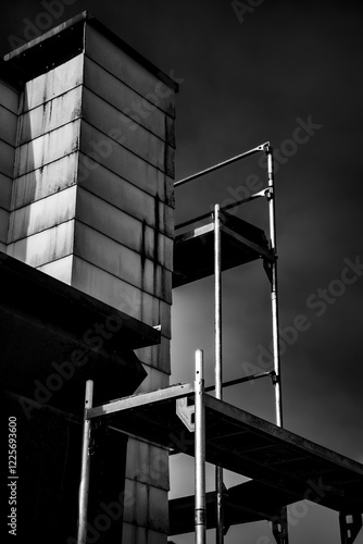 Schwarz-weiß Foto eines Baugerüsts vor heruntergekommener Fassade