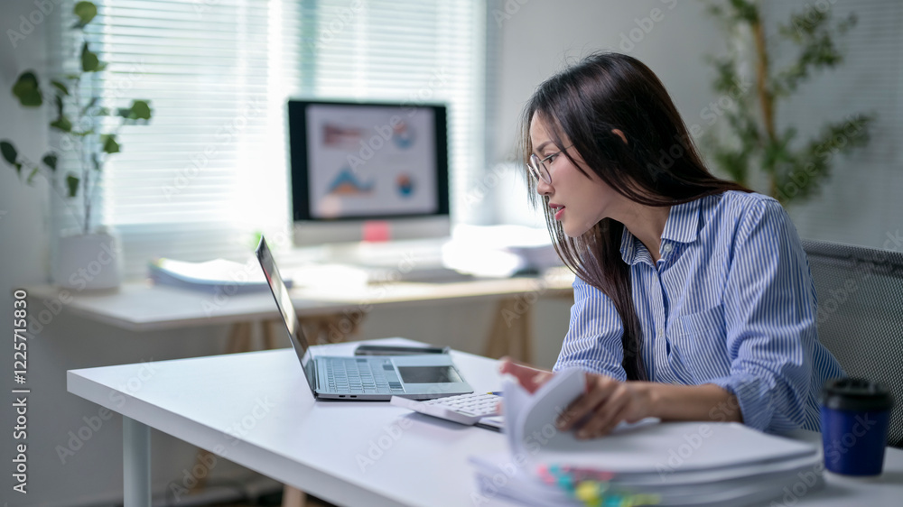 A woman is sitting at a desk with a laptop and a keyboard A woman is sitting at a desk with a laptop and a keyboard