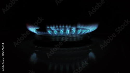 Slow-motion effect of gas stove burner igniting, showing flames appearing gradually.