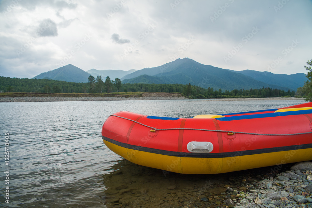 Fototapeta premium The raft for rafting is located on the river bank. Mountains are visible in the background.