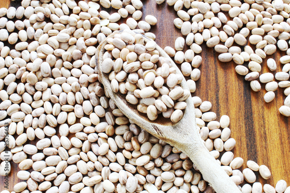 Obraz premium Carioca beans in a wooden spoon on the rustic table. Brazilian seeds.