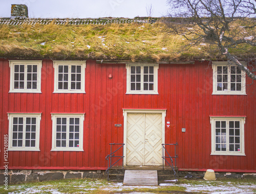 Bright red old building with grassroof photo