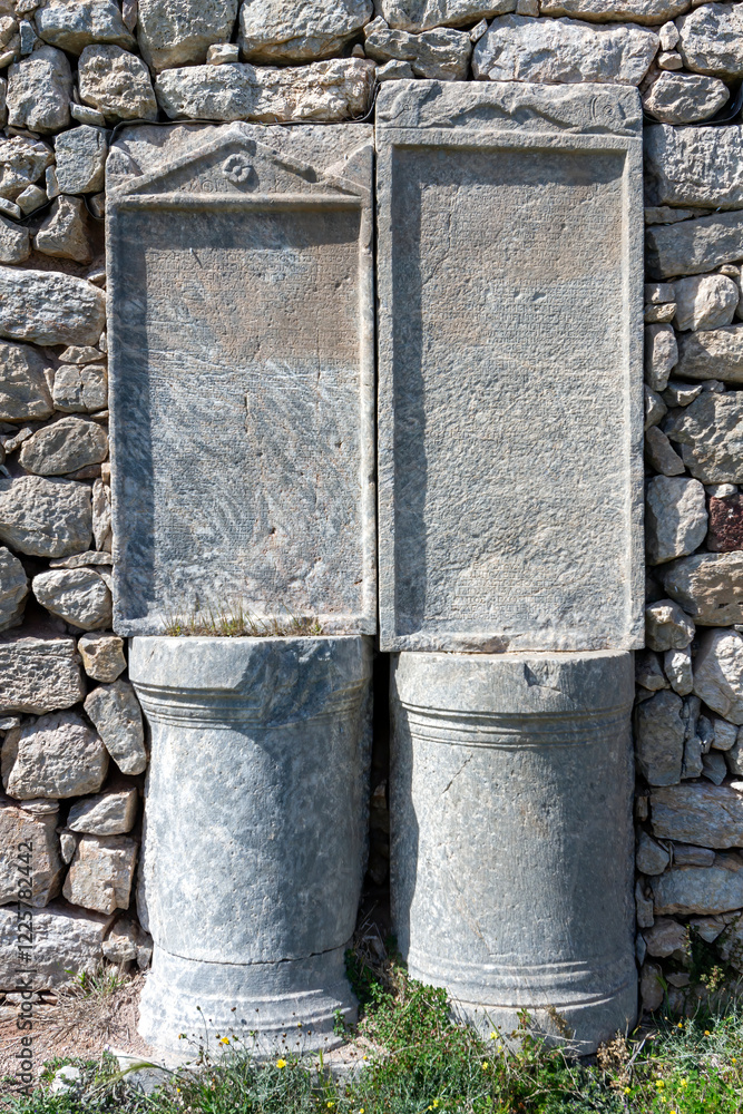 Ancient Greek stone inscriptions in the ruins of Thera, Santorini, Greece, Europe. Historical archaeological site showcasing classical Greek heritage.