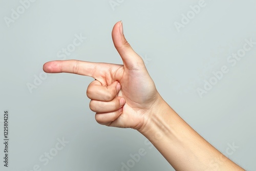 Hand forming a finger gun gesture against a gray background, minimalistic symbolic pose, close-up of playful and expressive sign, clean and modern composition, isolated hand gesture

