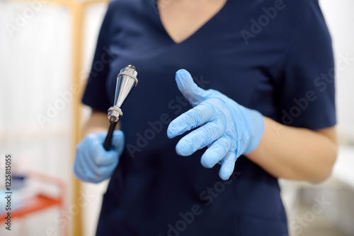 Fotografia Doctor is checking the neurological reflexes of patient with hammer