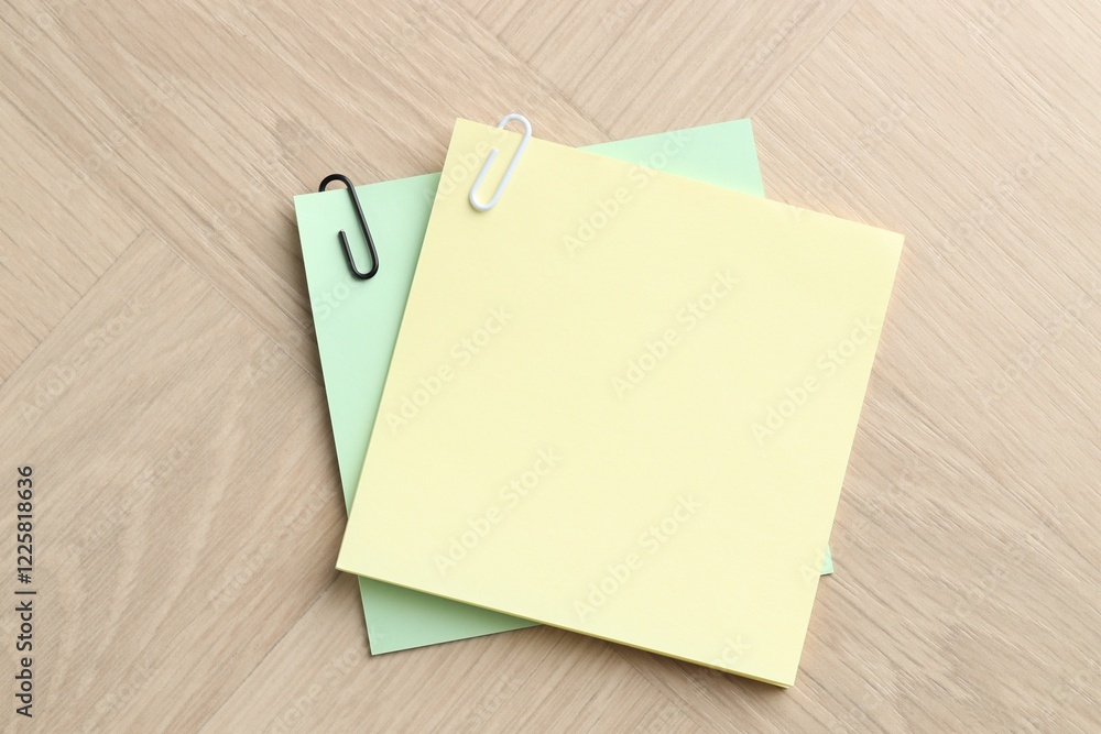 Paper notes with clips on wooden table, top view. Space for text Paper notes with clips on wooden table, top view. Space for text