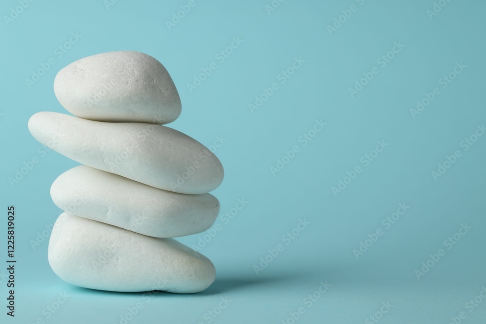 Stack of rocks on light blue background, space for text. Harmony and life balance Stack of rocks on light blue background, space for text. Harmony and life balance