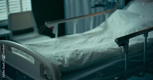 Empty hospital bed with neatly arranged sheets and pillow.