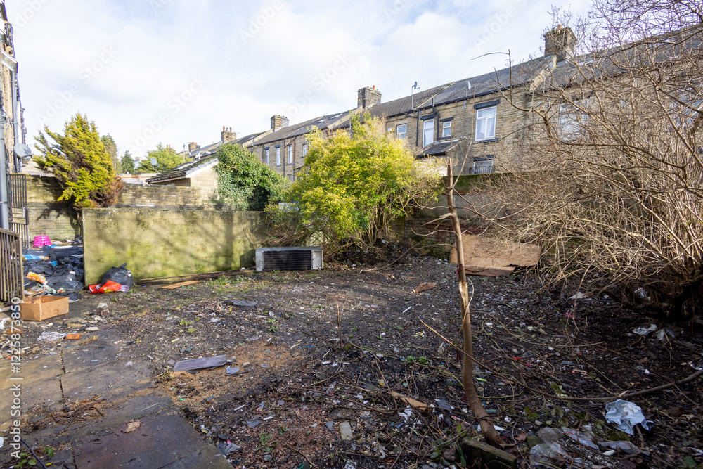 Photo of an extremely run down property garden showing rubbish in the unkept garden of a family home in the winter time