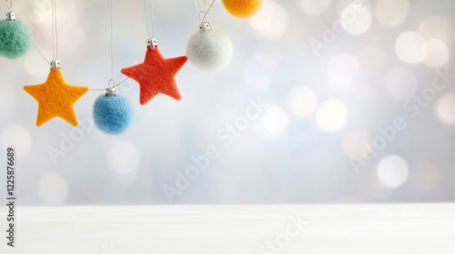 DIY Christmas garland made of colorful felt stars and pom-poms hanging against a blurred background with bokeh effect, adding a touch of festive cheer to white surface photo