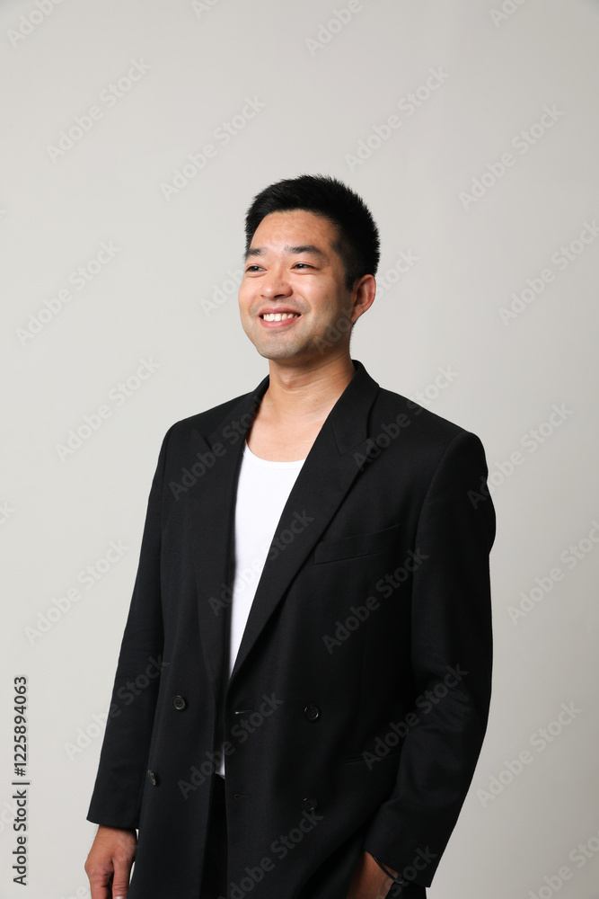 Portrait of young Asian man with a thoughtful and optimistic face expression. Vertical. Portrait of young Asian man with a thoughtful and optimistic face expression. Vertical.