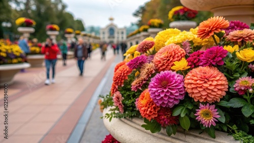 Closeup of a vibrant flower arrangement at the entrance of the plaza bringing a burst of color and life while visitors wander by snapping photos and admiring the scenery. photo