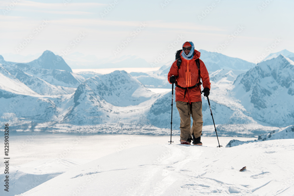 Smiling skier tourist standing on the top of the mountain on skis Smiling skier tourist standing on the top of the mountain on skis