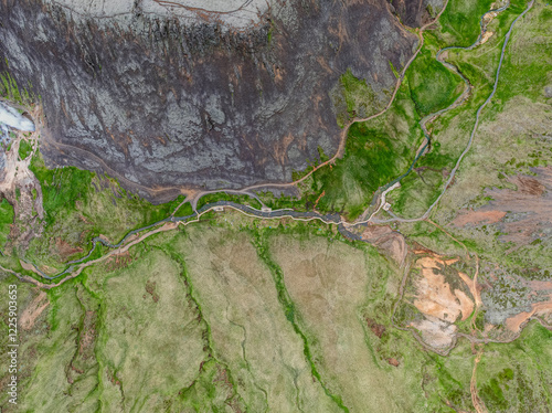 Drone aerial view of Reykjadalur Hot Spring Thermal River with scenic valley with stream and rugged mountain landscape in Iceland