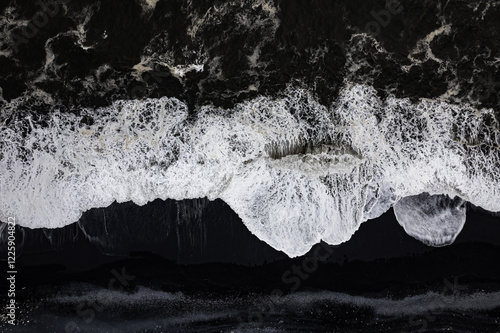 Aerial drone view of epic ocean waves crashing on the shoreline black beach Reynisfjara in Iceland in VIK Myrdal in Golden Circle Area