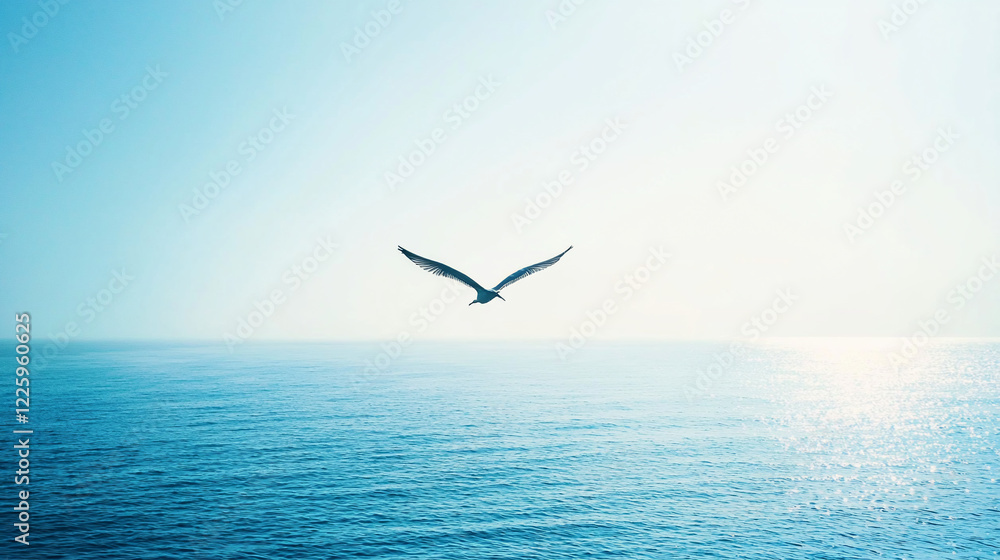 Fototapeta premium A solitary bird soaring over a tranquil ocean at sunrise, creating a serene and peaceful atmosphere