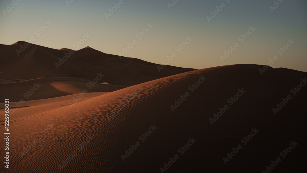 Fototapeta premium Stunning view of the sun setting over the erg chebbi dunes in the sahara desert near merzouga, morocco