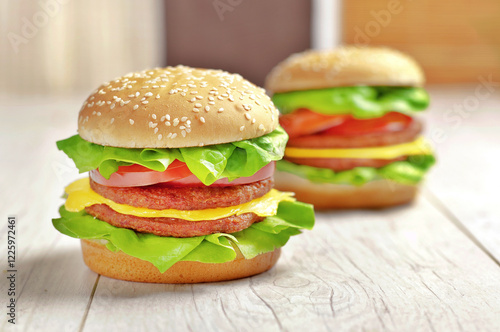 Obraz na plátně Burgery z mięsem, serem, sałatą i pomidorem