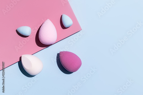 Array of colorful makeup sponges on a dual-tone background photo