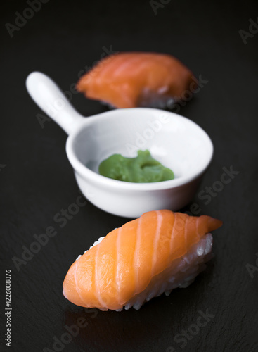 Delicious sushi and wasabi on a black stone surface photo