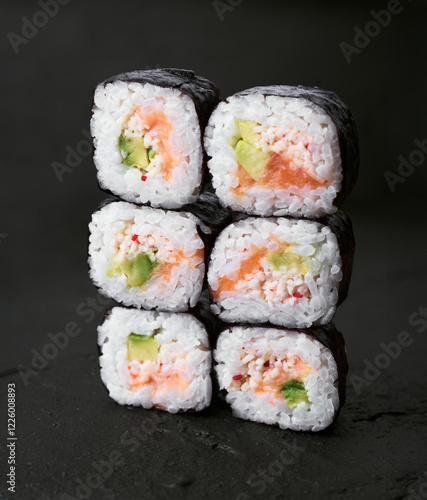 Delicious sushi rolls displayed on a dark stone background photo