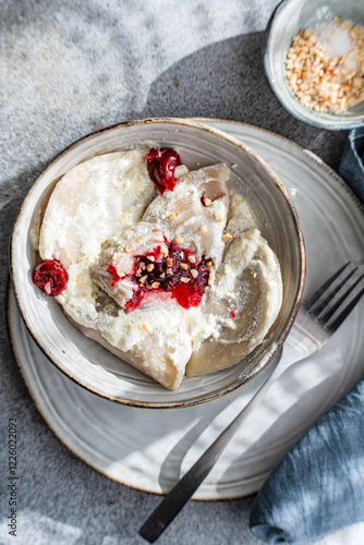 Ukrainian varenyky with cherry, sour cream, and nuts delight photo