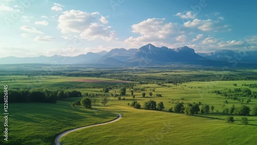 Serene Landscapes: A Drone's Aerial View of Fields, Mountains, and Winding Roads