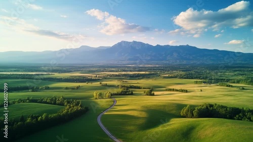 Serene Landscapes: A Drone's Aerial View of Fields, Mountains, and Winding Roads