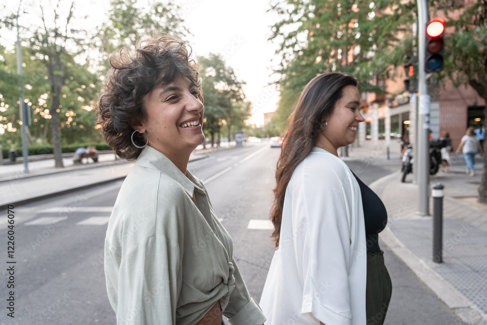 Lesbian couple enjoying a walk and laughing together outdoors Lesbian couple enjoying a walk and laughing together outdoors