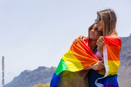 Embracing LGBTQIA pride with vibrant rainbow flag outdoors photo