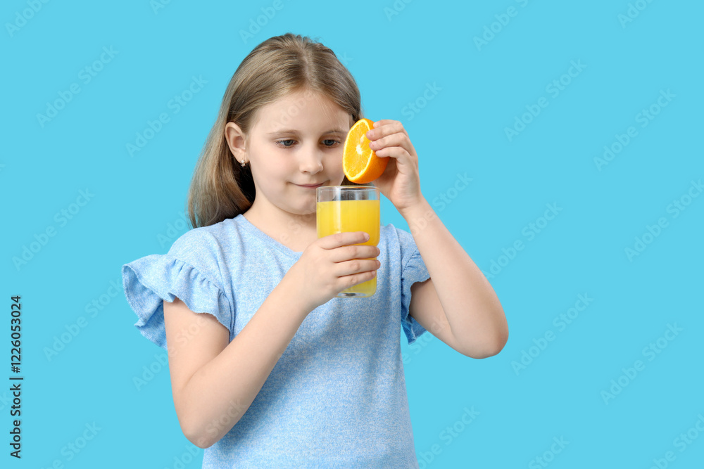 Cute little girl with glass of juice and orange on blue background Cute little girl with glass of juice and orange on blue background